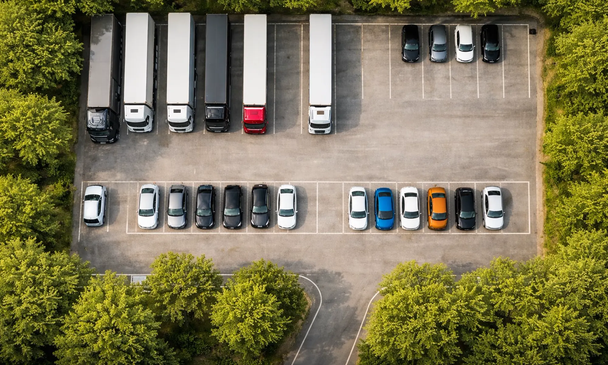 Flygvy över en blandad flotta av lastbilar och bilar parkerade i rader